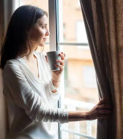 Canva-Happy-Beautiful-Woman-Drinking-Hot-Coffee-Looking-on-Window-at-H-1