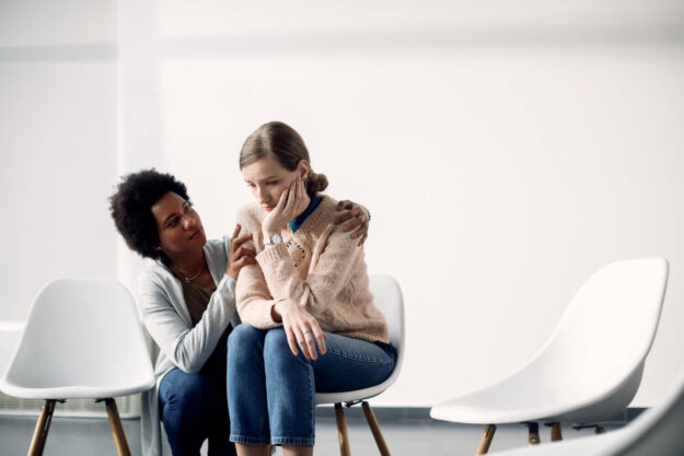 caring-african-american-woman-consoling-sad-woman-before-group-therapy-meeting-1 drug rehab that accepts medicaid
