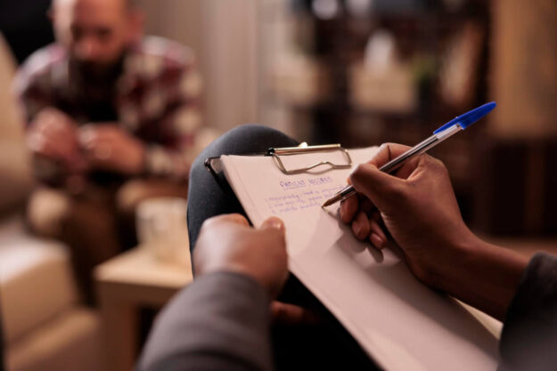 male-psychologist-taking-notes-couple-therapy-session-help-with-relationship-issues-counselor-giving-advice-explaining-marriage-problems-using-paper-psychoanalysis-close-up-1 inpatient drug rehab clinic